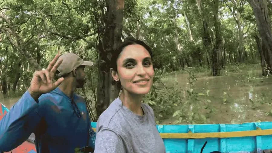 Two conservation volunteers traveling through a flooded forest by boat